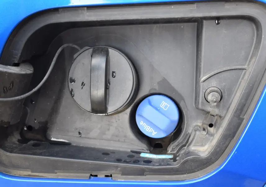 Gros plan sur le bouchon AdBlue bleu et le réservoir diesel du Peugeot 2008 bleu, côté gauche, version 2021.