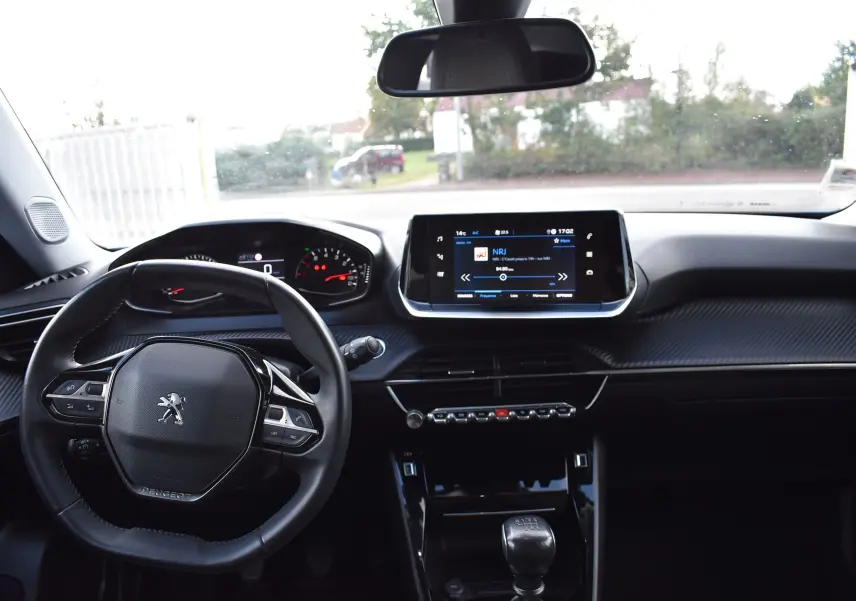 Intérieur du Peugeot 2008 2021 bleu, vue du poste de conduite avec volant, tableau de bord et écran tactile central.