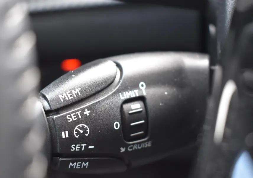 Gros plan sur la commande de régulateur de vitesse du Peugeot 2008 bleu 2021 version BlueHDi 110 Allure.
