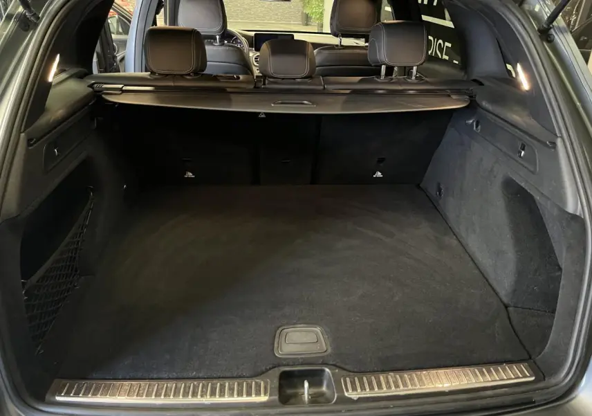 Coffre ouvert d'un Mercedes GLC gris, vue arrière montrant l'espace de chargement et la banquette arrière.