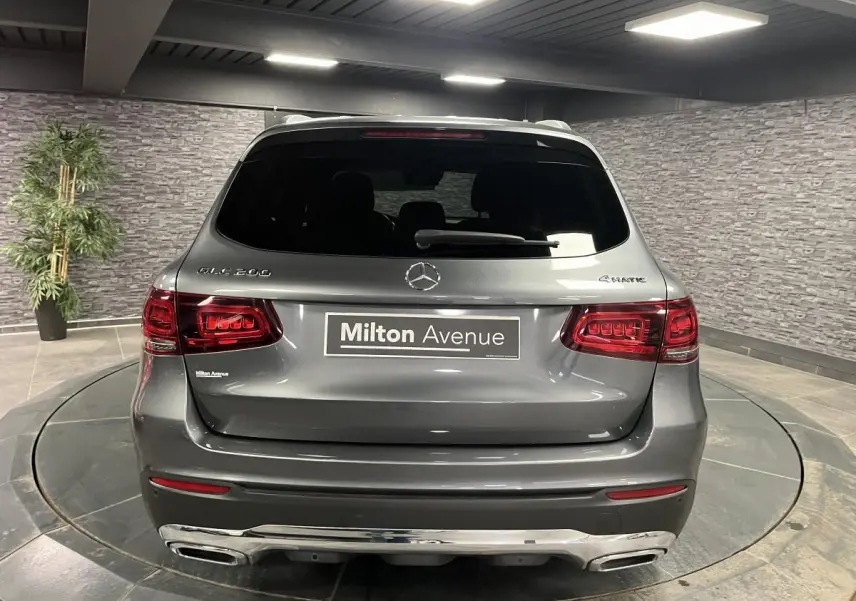 Vue arrière d'un Mercedes GLC 200 4MATIC gris métallisé avec feux LED et double sortie d'échappement chromée.