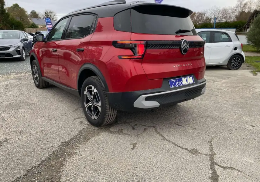Vue 3/4 arrière droite d'un Citroën C3 Aircross rouge Elixir avec toit noir et feux arrière LED 3D.