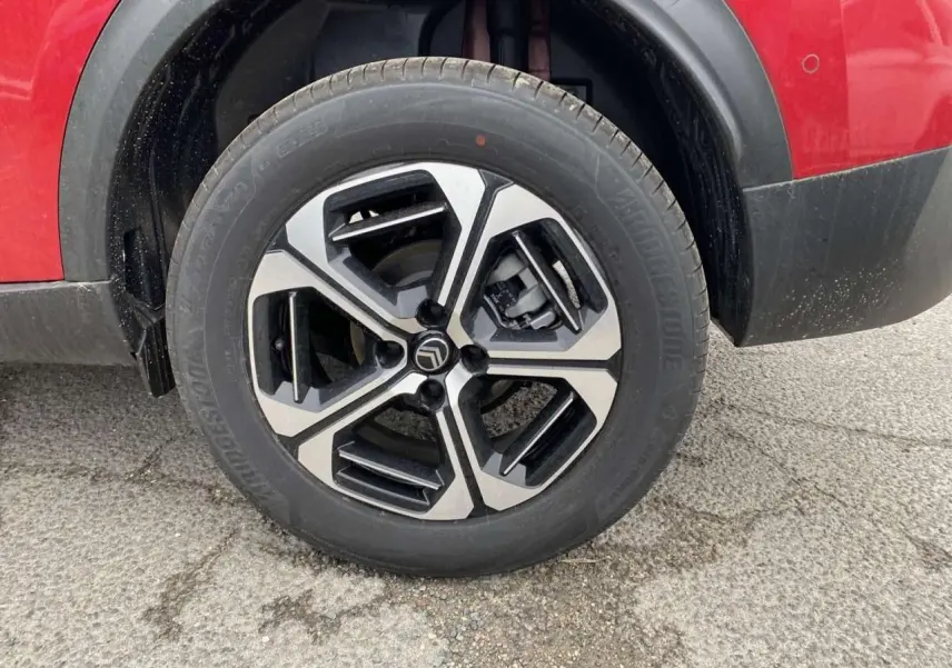 Gros plan sur la roue avant gauche du Citroën C3 Aircross rouge Elixir avec jante alliage 17'' Aragonite diamantée.