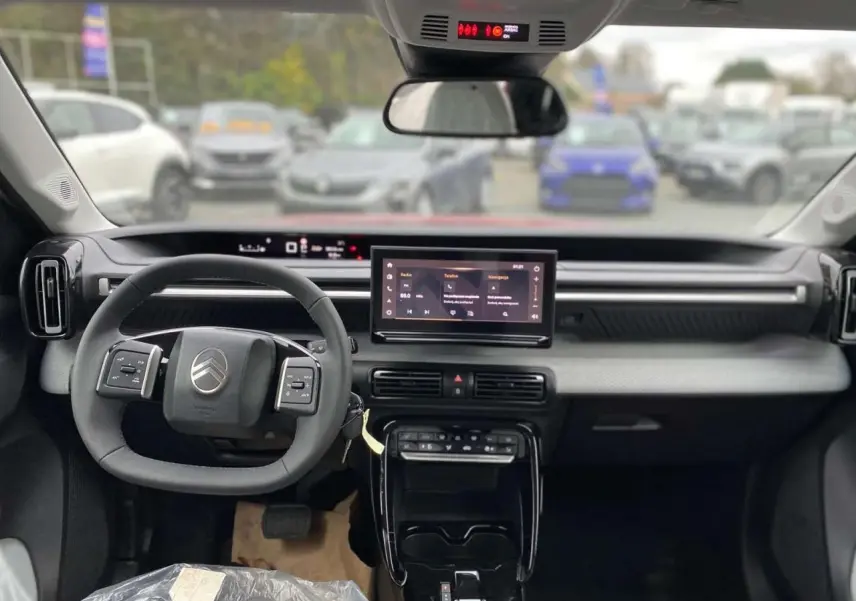 Intérieur avant du Citroën C3 Aircross 2025, tableau de bord gris, volant multifonctions et écran tactile central.