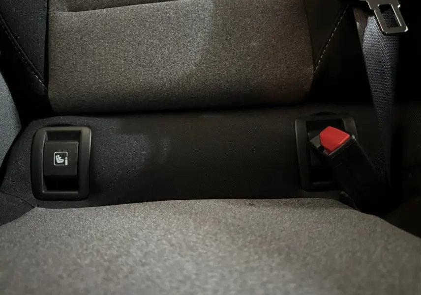 Gros plan sur la banquette arrière grise de la Renault Clio 2025 avec bouton Isofix et ceinture de sécurité.