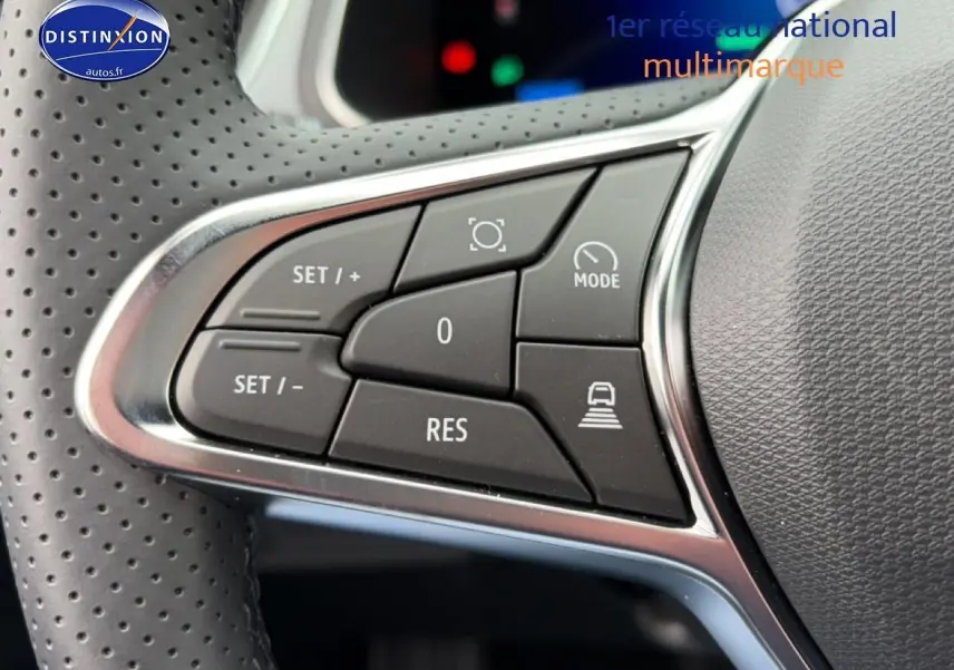 Gros plan sur les commandes multifonctions noires et chrome du volant perforé du Renault Symbioz gris schiste.
