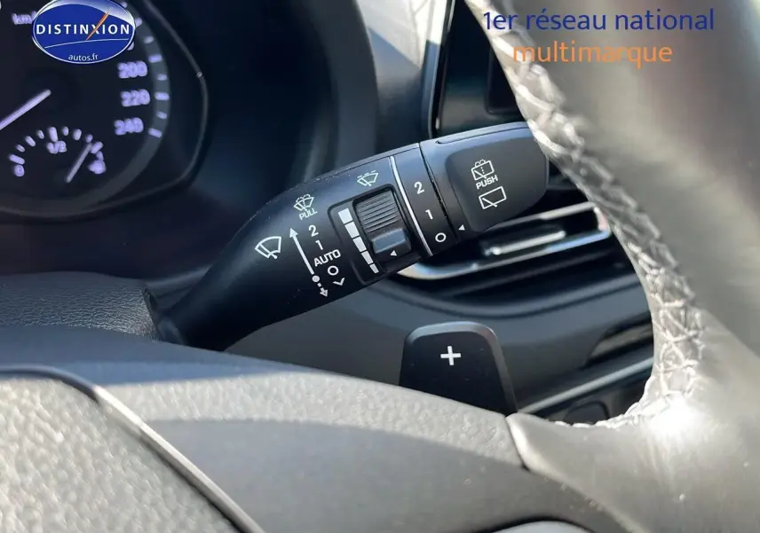 Gros plan sur la commande d'essuie-glace et palette de changement de vitesse du volant cuir d'une Hyundai i30 gris argent 2024.