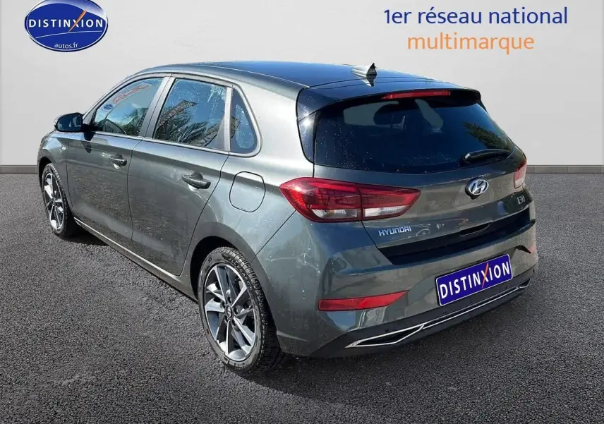 Vue 3/4 arrière droite d'une Hyundai i30 gris argent 2024 avec jantes alu et vitres arrière surteintées.