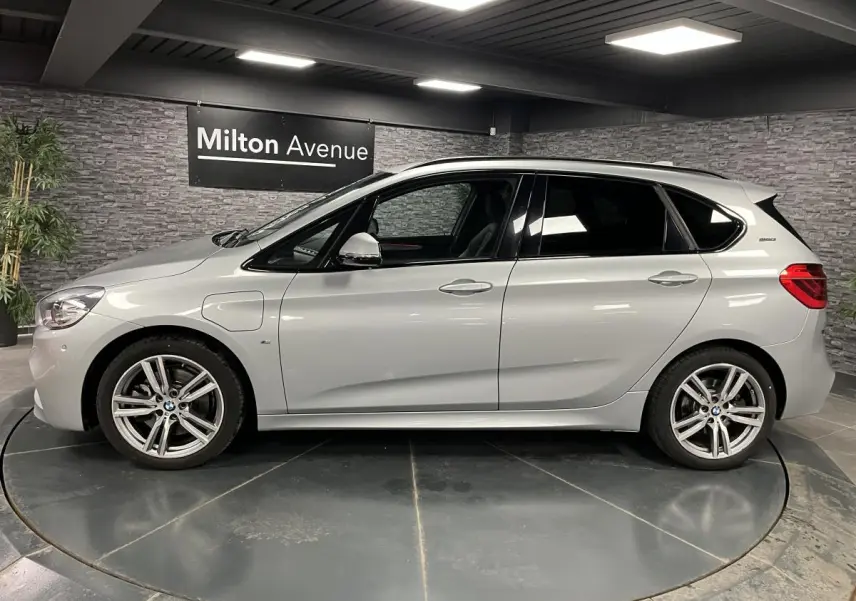 BMW Série 2 225xe Active Tourer hybride gris vue de profil côté gauche en intérieur showroom