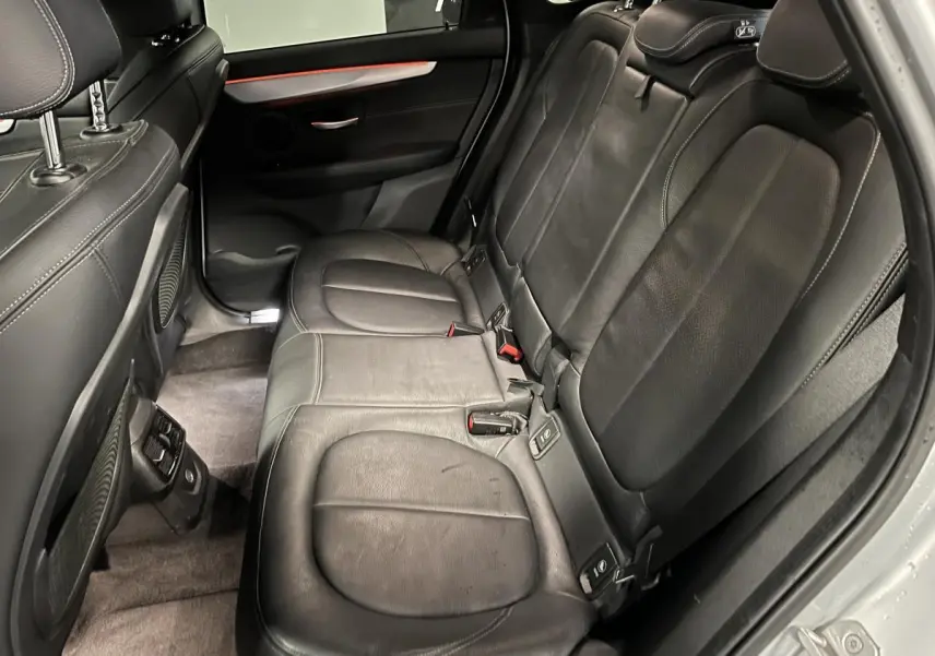 Vue côté droit de la banquette arrière en cuir noir perforé de la BMW Série 2 225xe Active Tourer gris.