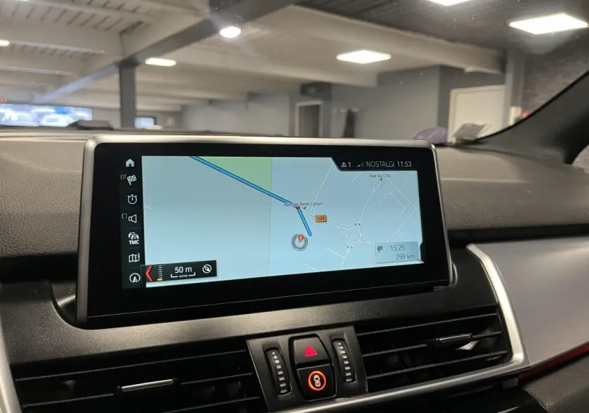Écran central de navigation affichant une carte, dans l'habitacle gris d'une BMW Série 2 Active Tourer 225xe hybride.