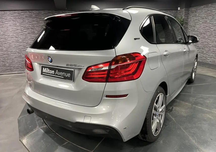 BMW Série 2 225xe Active Tourer gris vue 3/4 arrière droit avec feux arrière rouges et jantes alliage 18 pouces