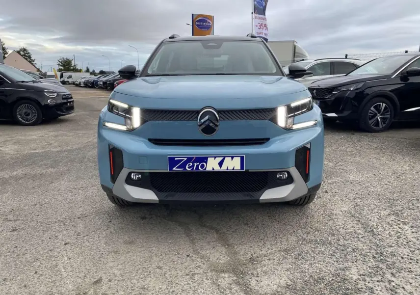 Vue frontale d'un Citroën C3 Aircross hybride bleu Monte Carlo avec toit noir et feux LED allumés.