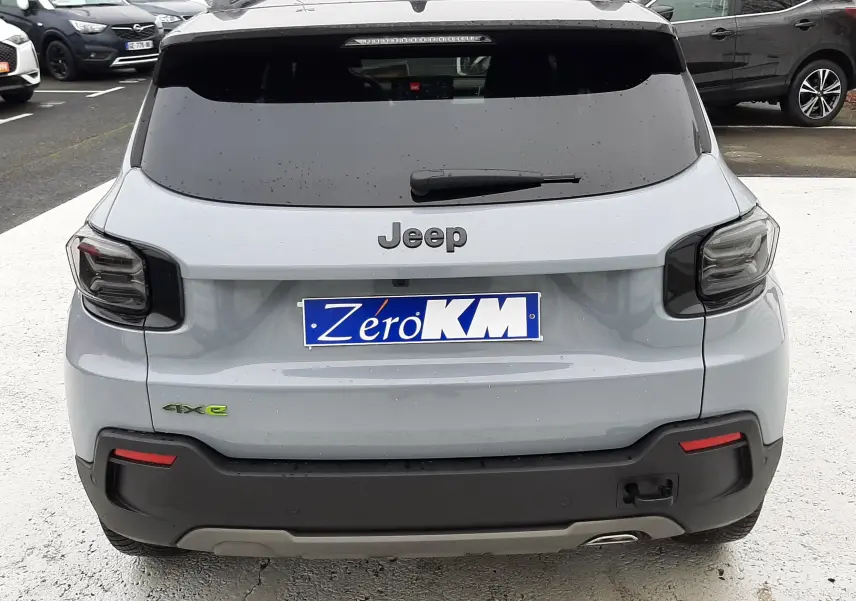 Vue arrière d'un Jeep Avenger gris Storm avec toit noir, badge 4xe vert et feux arrière fumés.