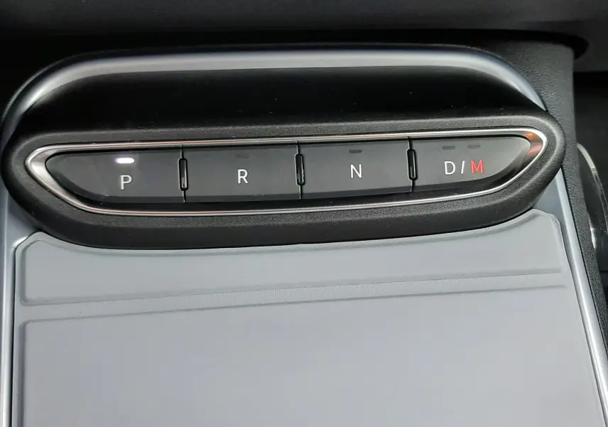 Gros plan sur la commande de boîte automatique du Jeep Avenger, boutons P, R, N, D/M avec éclairage blanc et rouge.