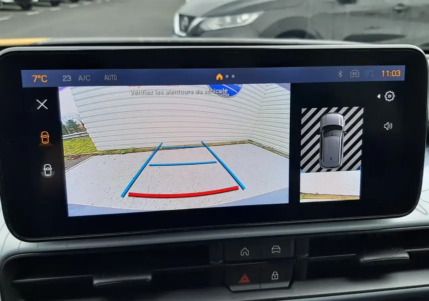 Vue de l'écran intérieur montrant la caméra de recul et l'affichage 360° du Jeep Avenger gris Storm avec toit noir.