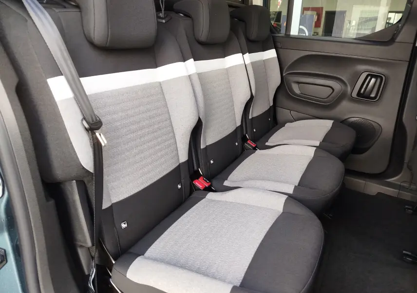 Vue intérieure côté droit des sièges arrière gris clair et foncé du Citroën Berlingo M 2025, avec ceinture de sécurité visible.