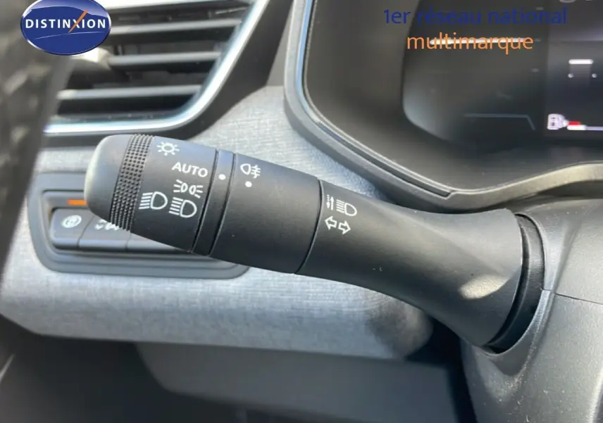 Gros plan sur la commande des feux et clignotants dans l’habitacle gris d’une Renault Clio 2025.