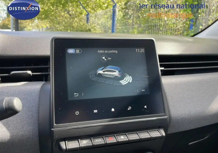 Vue intérieure centrée sur l’écran tactile du tableau de bord de la Renault Clio gris schiste, affichant l’aide au parking.