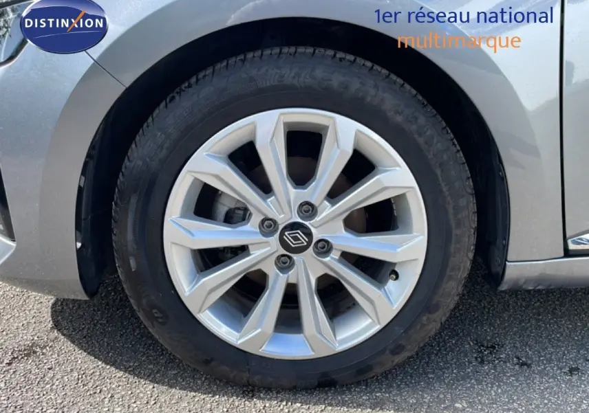 Gros plan sur la roue avant gauche d'une Renault Clio gris schiste métal avec jante alliage à plusieurs branches.