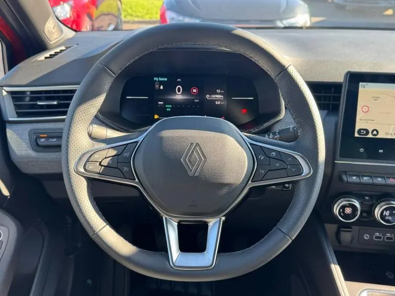 Vue rapprochée du volant en cuir noir de la Renault Clio 2025 avec tableau de bord numérique et écran tactile latéral.