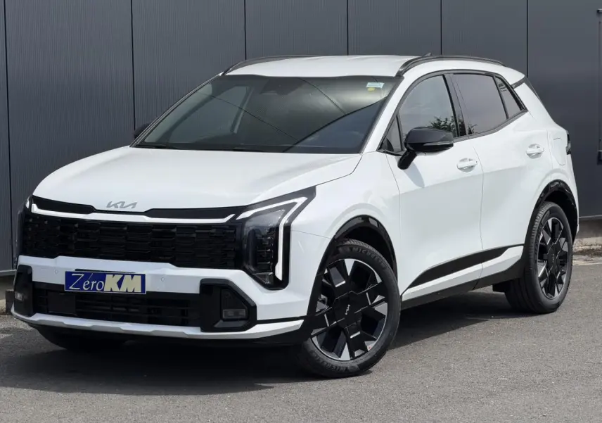 KIA SPORTAGE blanc en 3/4 avant droit, avec calandre noire et jantes alliage 19 pouces distinctives.