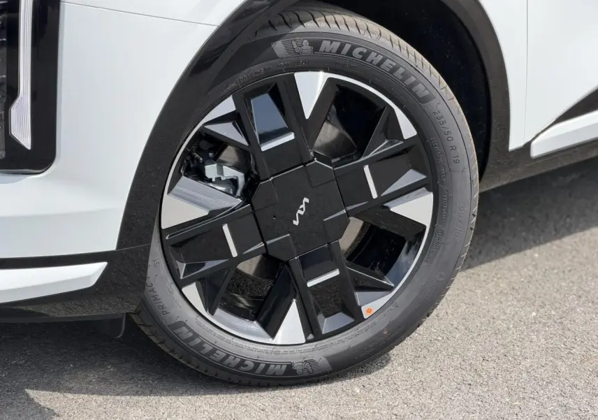 Gros plan sur la roue avant droite du KIA SPORTAGE blanc avec jante alliage noire et argentée, pneus Michelin.