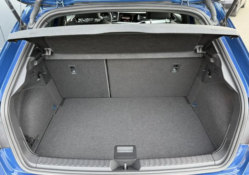 Coffre ouvert vu de l'arrière d'une Audi A1 Sportback 30 TFSI bleu Ascari avec intérieur de coffre gris.