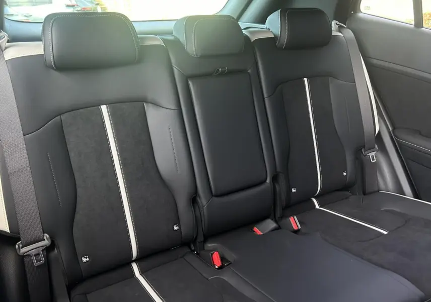 Vue intérieure des sièges arrière bi-ton noir et gris du Kia Sportage 2026 GT-line avec ceintures et appuie-têtes intégrés.