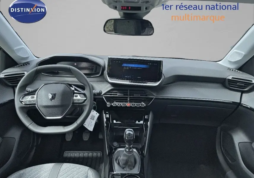 Vue intérieure frontale du tableau de bord et volant de la Peugeot 208 jaune Agueda Metal, avec boîte manuelle visible.