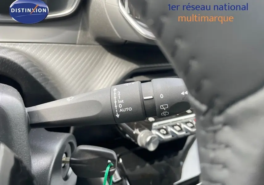 Gros plan sur la commande d'essuie-glace et le contacteur du tableau de bord d'une Peugeot 208 jaune Agueda Metal.