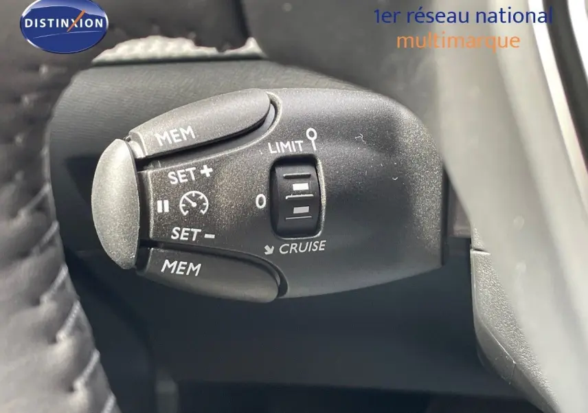 Gros plan sur la commande de régulateur de vitesse de la Peugeot 208 jaune Agueda Metal, côté gauche du volant.