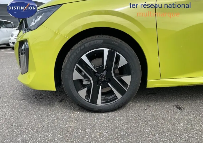 Gros plan sur la roue avant gauche d'une Peugeot 208 jaune Agueda Metal avec jante noire et argentée.