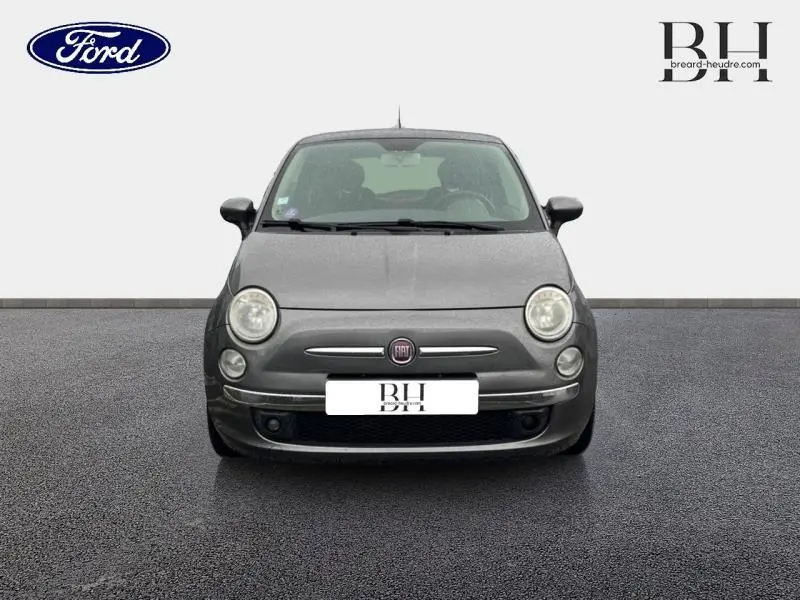 Vue frontale d'une FIAT 500 marron métal avec phares ronds et logo central sur fond neutre.