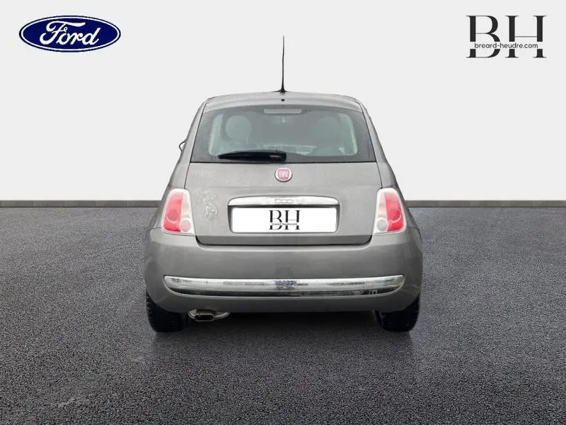 Vue arrière d'une FIAT 500 marron métallisée de 2010, avec feux arrière ronds et échappement visible côté gauche.