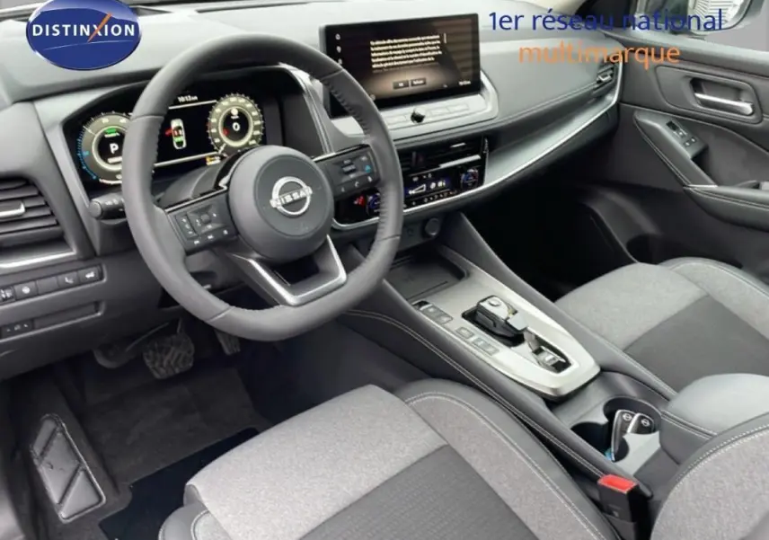Vue intérieure côté conducteur du Nissan Qashqai 1.5 E-POWER 2025, montrant le volant cuir multifonctions et l'écran tactile central.