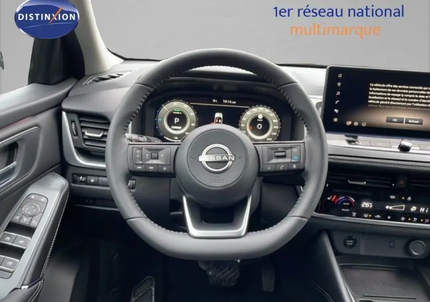 Vue intérieure centrée sur le volant cuir Nissan Qashqai noir avec cockpit numérique et écran tactile.