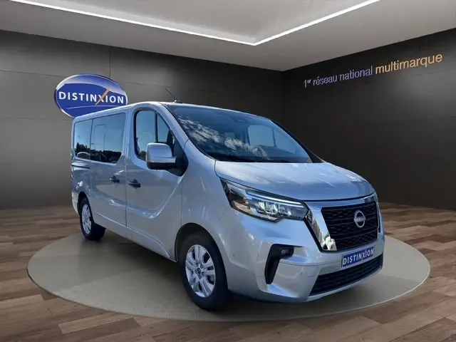 Vue 3/4 avant droite d’un Nissan Primastar gris clair avec calandre noire et phares LED dans un showroom.