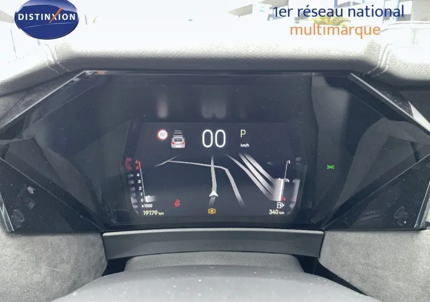 Vue rapprochée du tableau de bord numérique du DS4 gris laqué métal, affichant la navigation et les indicateurs de vitesse et carburant.