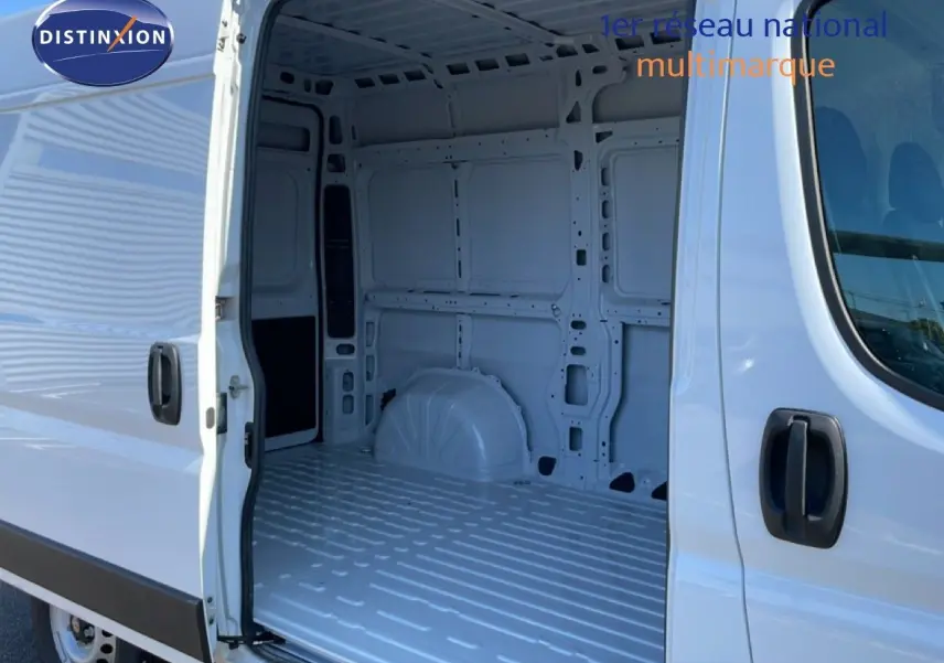 Vue latérale droite du Peugeot Boxer Fourgon blanc banquise avec porte coulissante ouverte montrant l’intérieur vide du coffre.