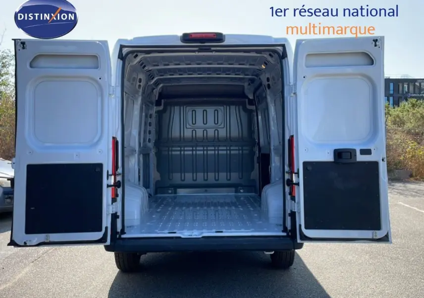 Vue arrière du Peugeot Boxer Fourgon blanc banquise 2025 avec portes ouvertes montrant l’espace de chargement vide.
