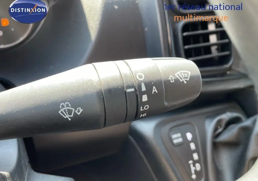 Gros plan sur la commande d’essuie-glace à gauche du volant dans l’habitacle du Peugeot Boxer blanc banquise.