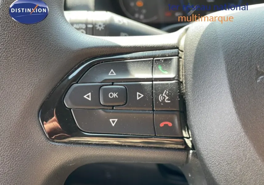Gros plan sur les commandes au volant du Peugeot Boxer Fourgon blanc banquise, avec boutons de gestion d'appel et navigation.