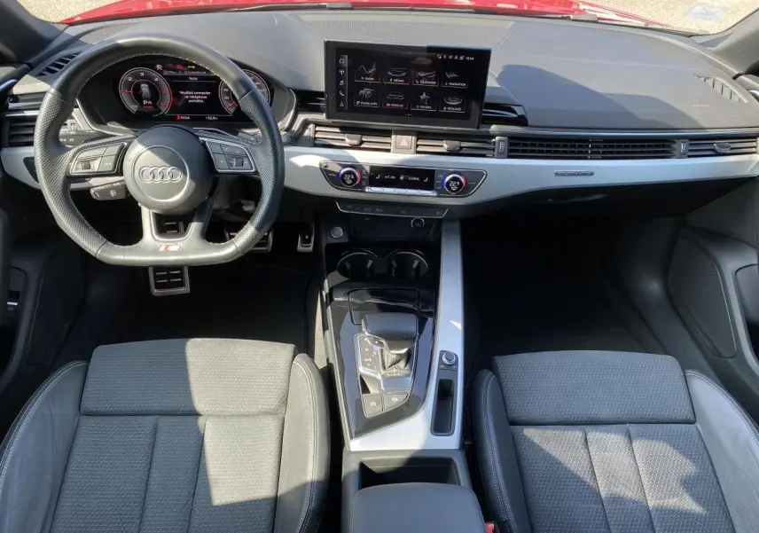 Vue intérieure frontale de l'Audi A4 Avant S line 2022, tableau de bord moderne avec écran central et volant multifonction cuir.