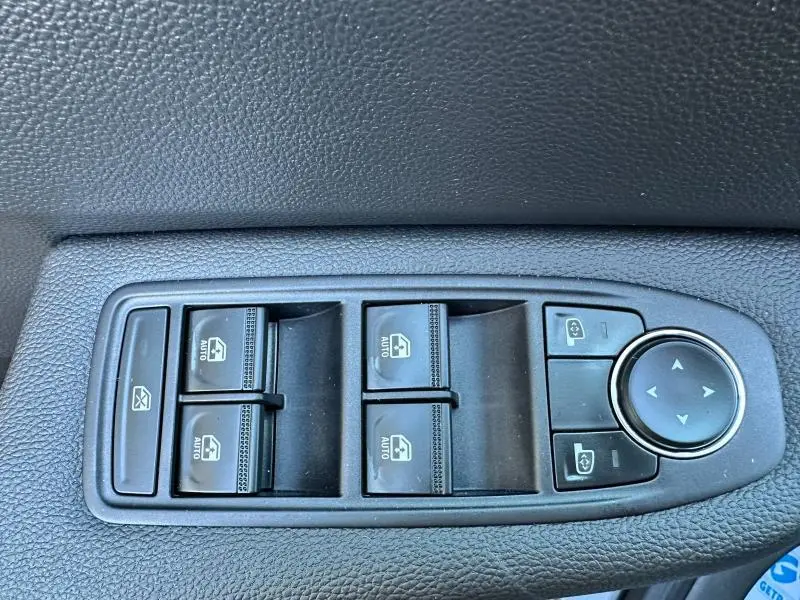 Panneau de commandes des vitres électriques et rétroviseurs côté conducteur dans une Renault Clio gris Rafale 2025.