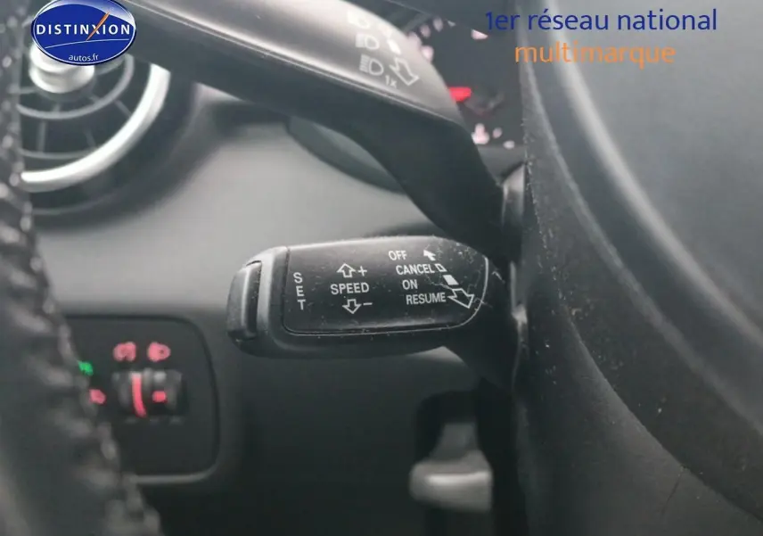 Gros plan sur la commande de régulateur de vitesse noire dans l’habitacle d’une Audi A1 blanche de 2015.