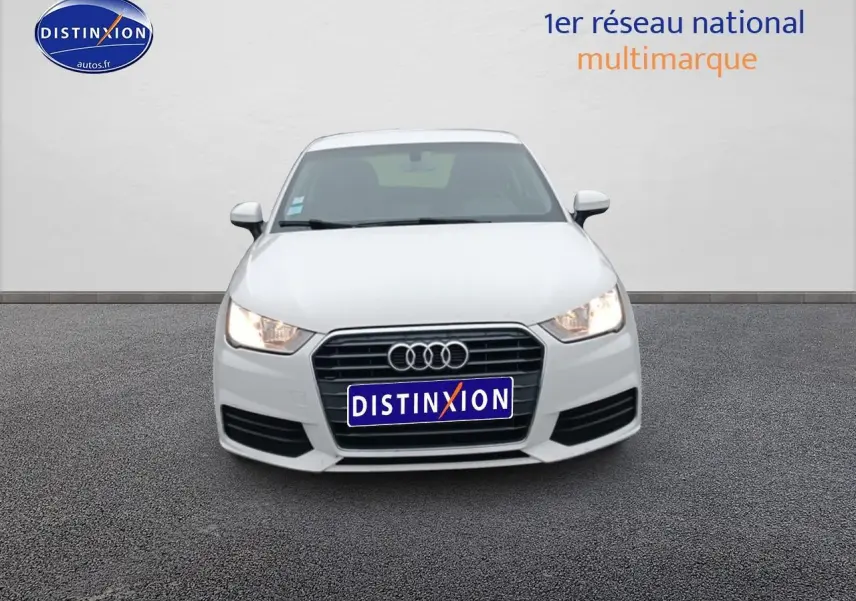 Vue avant d'une Audi A1 blanche de 2015 avec phares allumés et calandre noire distinctive.