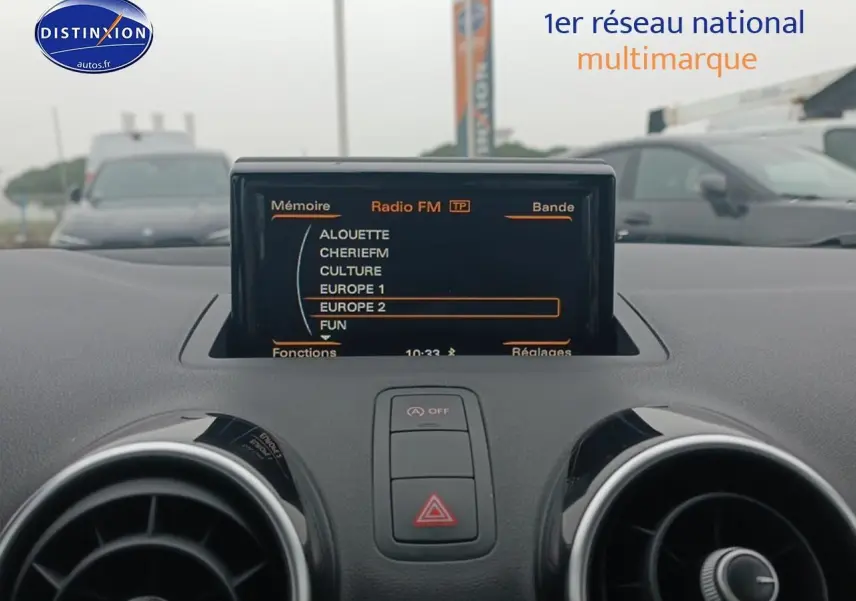 Affichage de l'écran multifonction radio FM sur le tableau de bord noir de l'Audi A1 blanc, vue intérieure frontale.