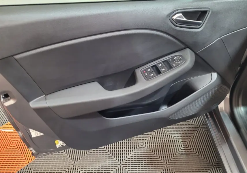 Vue rapprochée de la porte avant gauche gris foncé de la Renault Clio Evolution Blue dCi 100 avec commandes électriques.
