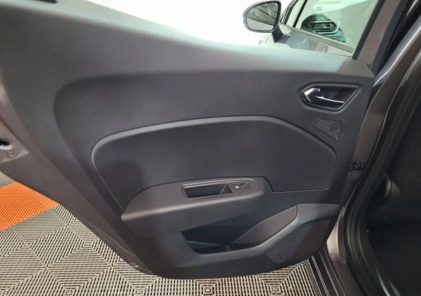 Vue intérieure de la porte arrière gauche grise foncée de la Renault Clio 2025 avec commande de fenêtre et haut-parleur intégré.